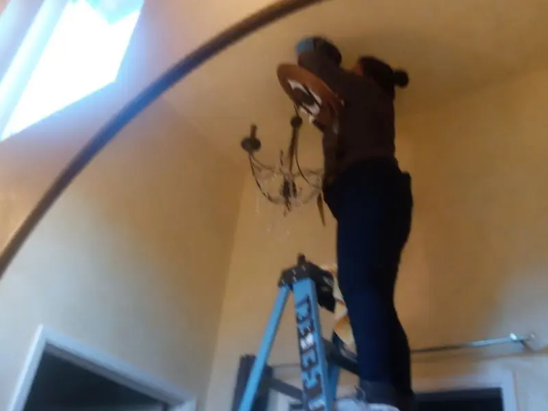 Electrician installing a chandelier in a Alamogordo residence